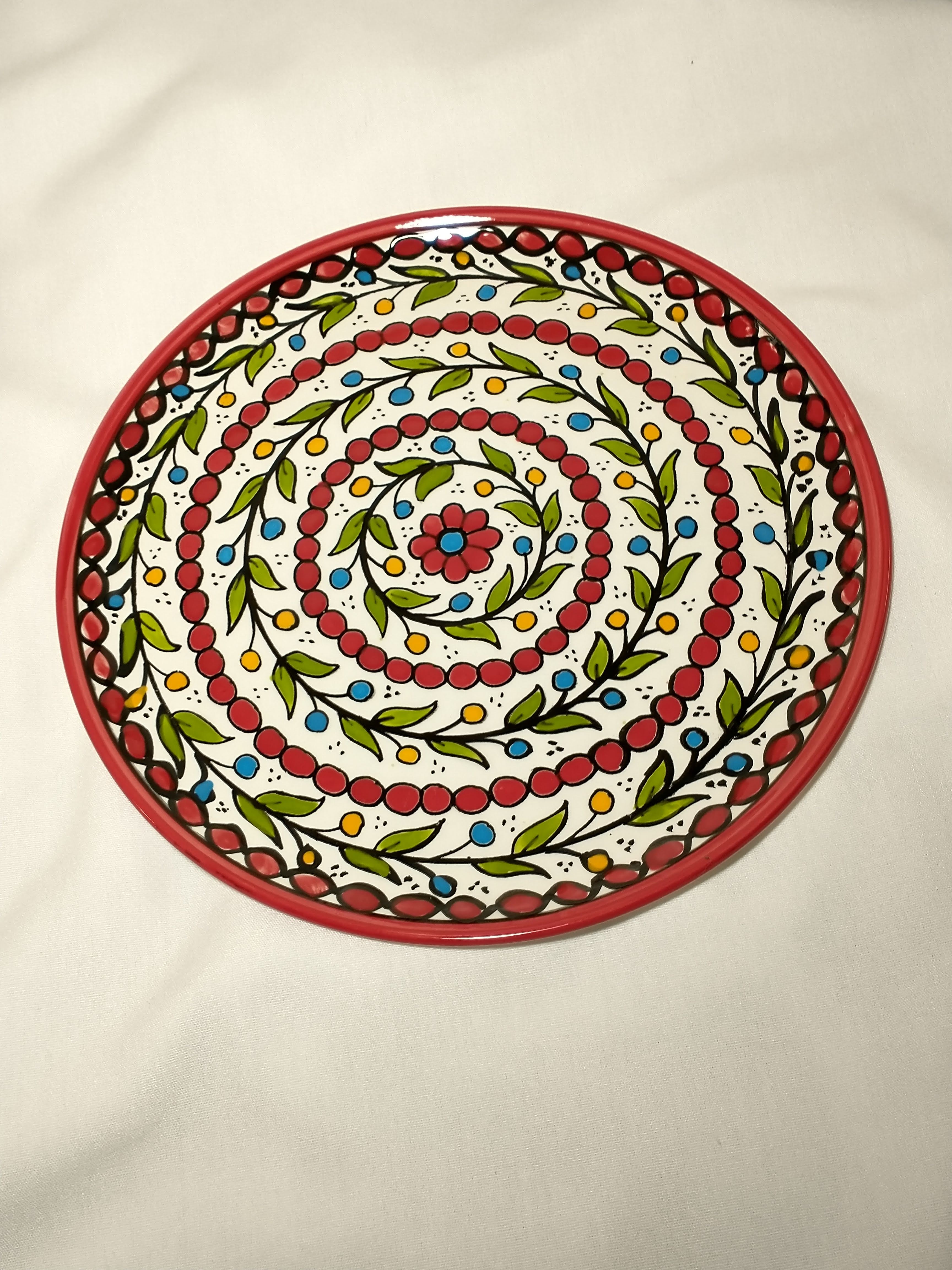 Plate with stem pattern spiraling and red circles with red flower in middle