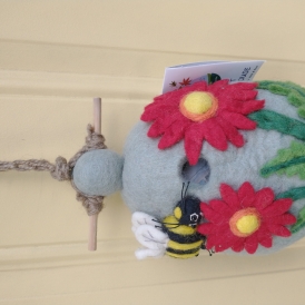 Bird house with bee and flowers